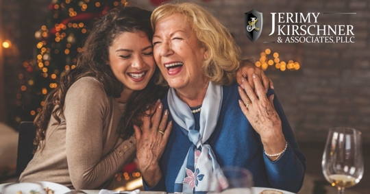 Older woman embracing her adult daughter at the dinner table