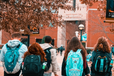 young people wearing backpacks walking
